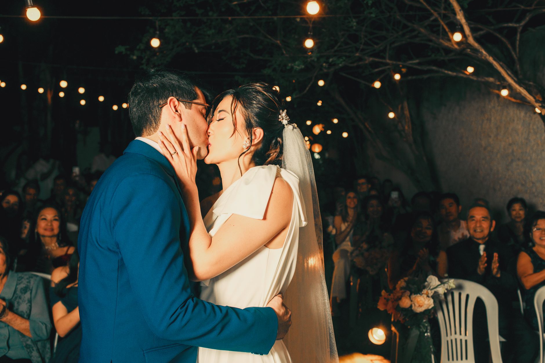 Couple sharing a kiss under enchanted outdoor setting
